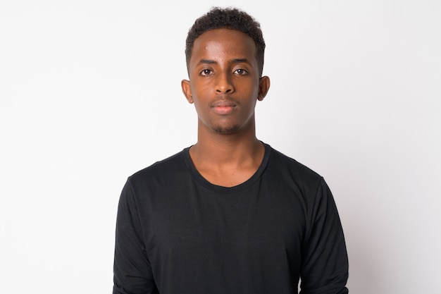 Portrait of young African man with Afro hair against white wall