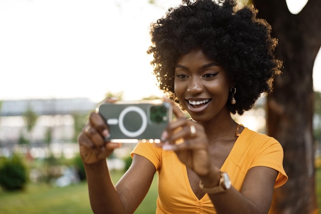 Portrait of a young afro american woman taking a selfie outdoor