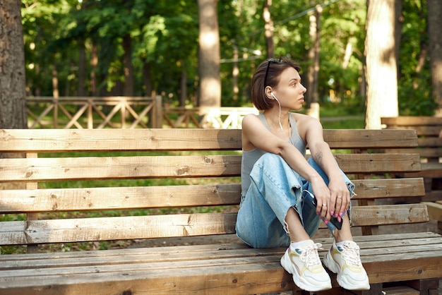 Portrait of a young american woman listening to music on phone