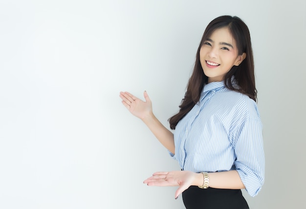 Portrait of young asian business woman presenting over white background.