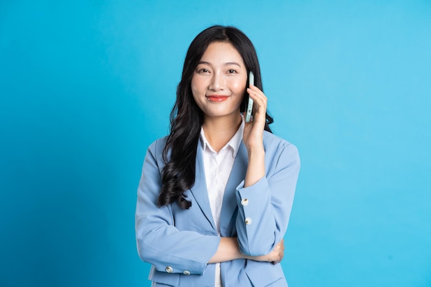 Portrait of young asian businesswoman posing on blue background