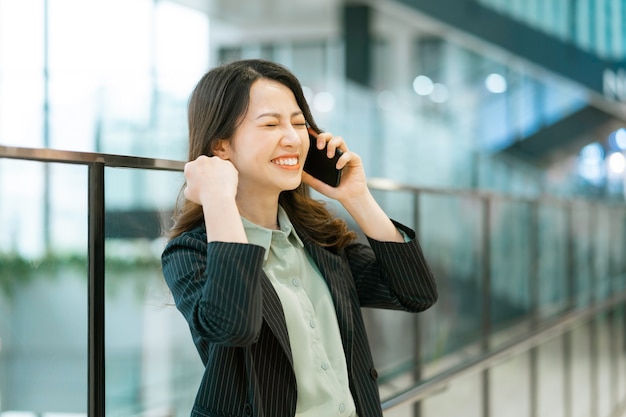 Portrait of a young Asian female director holding a phone