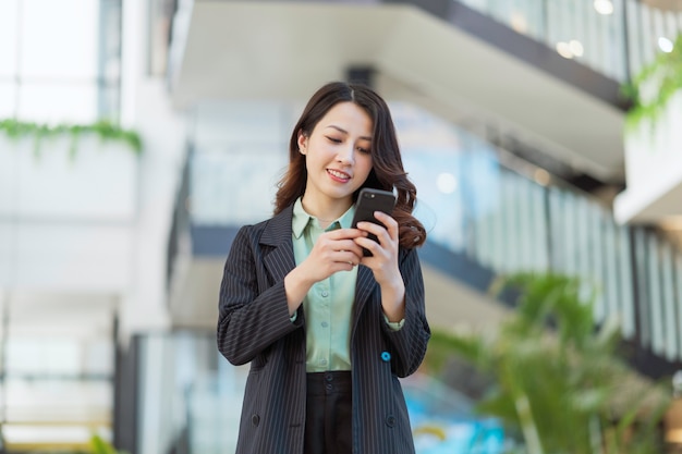 Portrait of a young Asian female director holding a phone