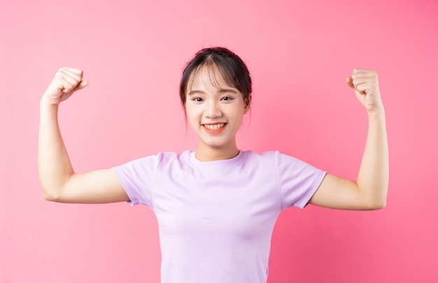 Portrait of young asian girl on pink background