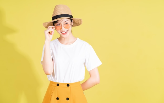 Portrait of young Asian girl on yellow background