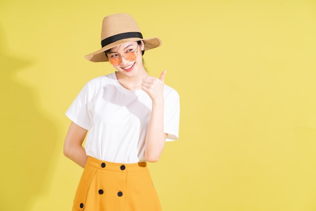 Portrait of young Asian girl on yellow background