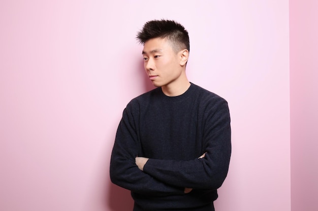 Portrait of young Asian man on color background