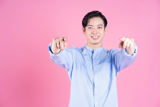 Portrait of young Asian man on pink background