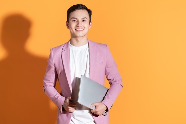 Portrait of young Asian man posing on background