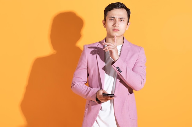 Portrait of young Asian man posing on background