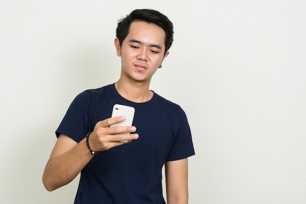 Portrait of young Asian man using phone