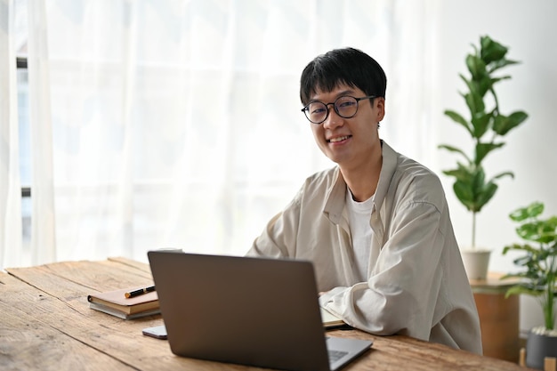 Portrait of young Asian man working with laptop in the living room