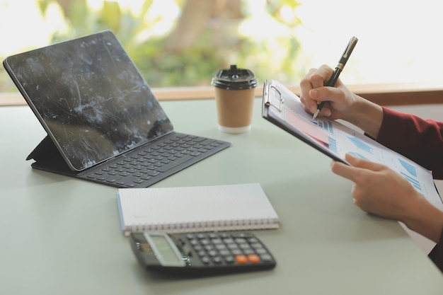 Portrait of Young Asian woman hand freelancer is working her job on computer tablet in modern office Doing accounting analysis report real estate investment data Financial and tax systems concept