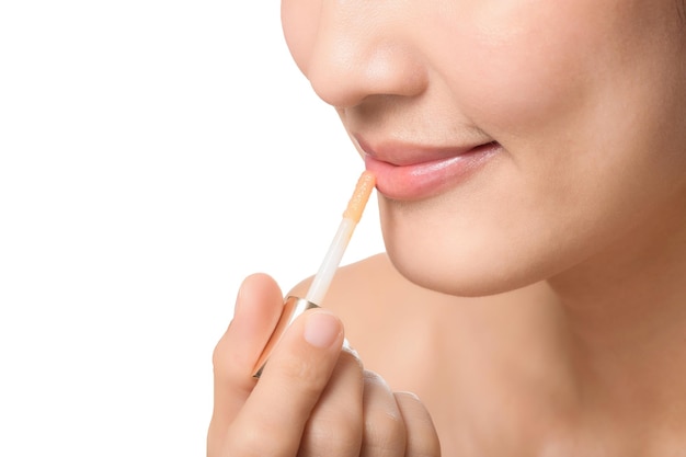 Portrait young asian woman looking mirror applying makeup lipstick at room