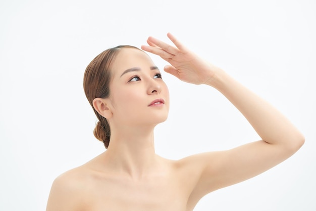 Portrait of young Asian woman looking to the side and showing hand on white background