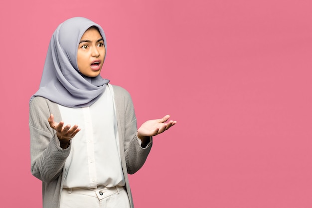 Portrait of young Asian woman raised hands with confused face