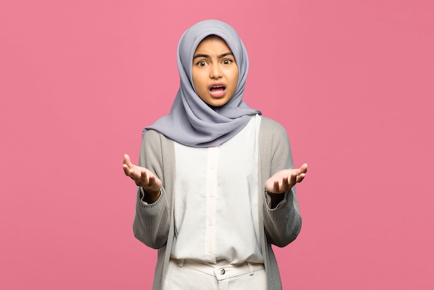 Portrait of young Asian woman raised hands with confused face