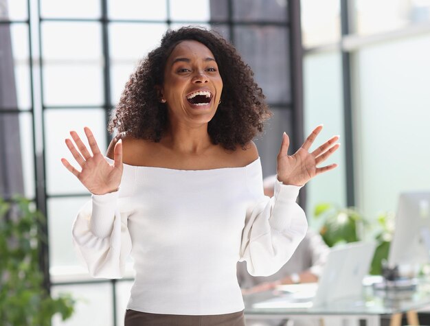 Portrait of a young attractive African American woman raised her hands up