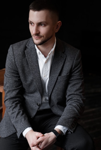 Portrait of a young attractive handsome elegant man on dark background