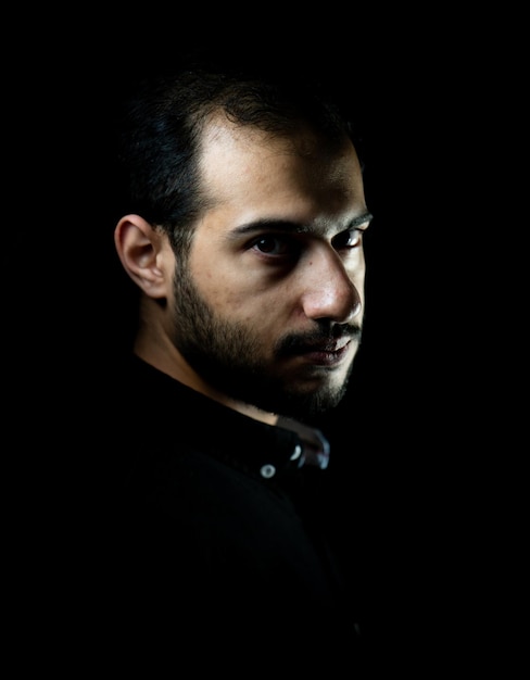 Portrait of young attractive man on a black background high quality photo