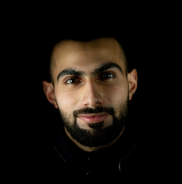 Portrait of young attractive man on a black background high quality photo