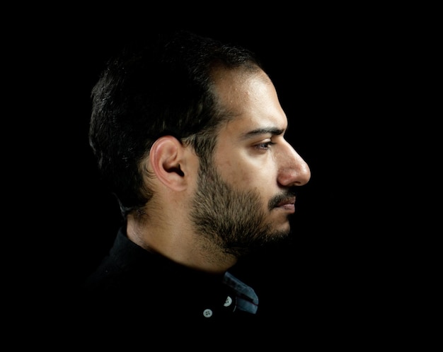 Portrait of young attractive man on a black background. High quality photo