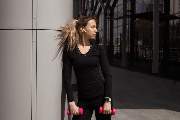 portrait of a young attractive woman with dumbbells