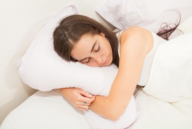 Portrait of a young attractive woman with long hair sleeping in her bed