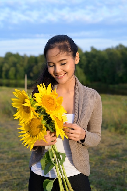 Portrait Of Young Beautiful Asian Woman Against Relaxing View Of The River And Lush Green Field