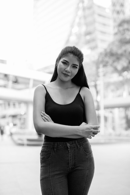 Portrait of young beautiful Asian woman exploring around the city in black and white