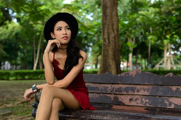 Portrait of young beautiful Asian woman at the park