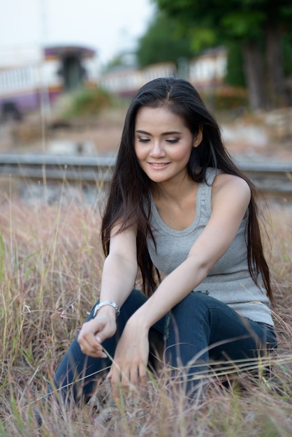 Portrait of young beautiful Asian woman at the railway station