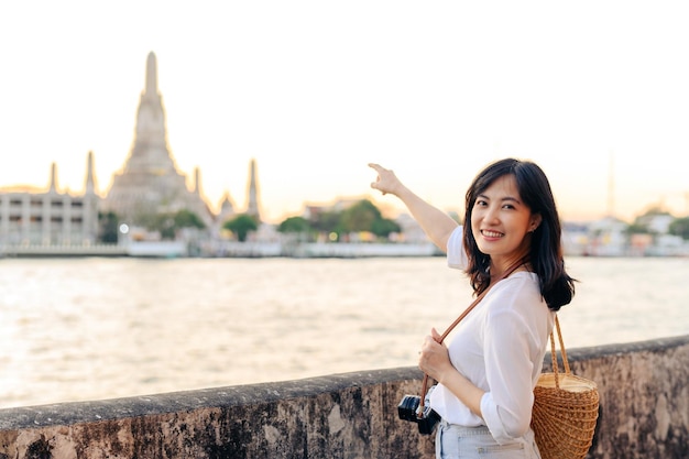 Portrait young beautiful asian woman smiling while travel at Wat Arun sunset view point Bangkok Thailand