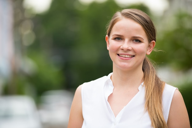 Portrait of young beautiful blonde businesswoman in the street outdoors