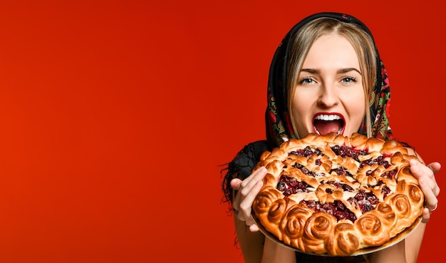 Portrait of a young beautiful blonde holding a delicious homemade cherry pie