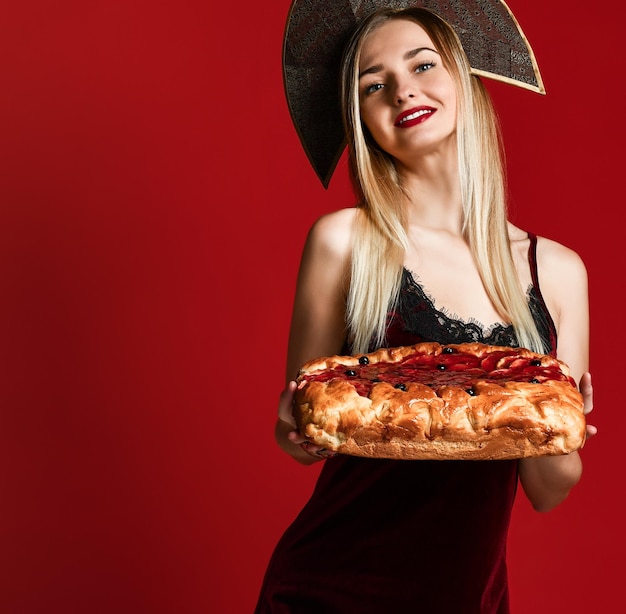 Portrait of a young beautiful blonde holding a delicious homemade cherry pie