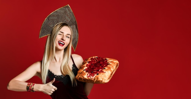 Portrait of a young beautiful blonde holding a delicious homemade cherry pie