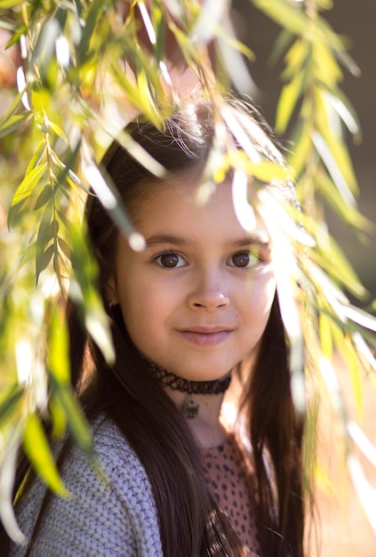 Portrait of a young beautiful brunette little girl outdoor in summer day Closeup portrait of a beaut