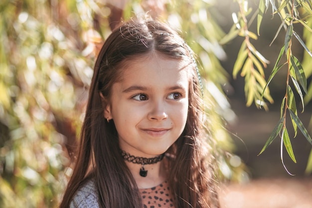 Portrait of a young beautiful brunette little girl outdoor in summer day Closeup portrait of a beaut