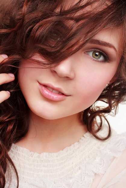 Portrait of a young beautiful brunette twenty year old woman isolated against white background