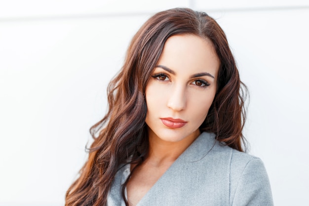 Portrait of a young beautiful brunette woman on white