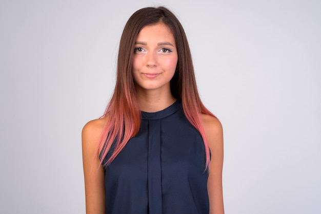 Portrait of young beautiful businesswoman against white wall