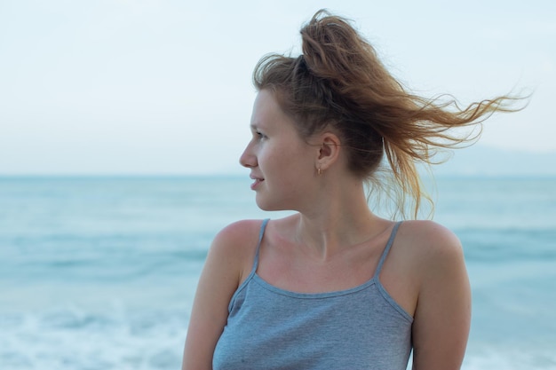 Portrait young beautiful girl on background embankment with sea ocean and island view smiling