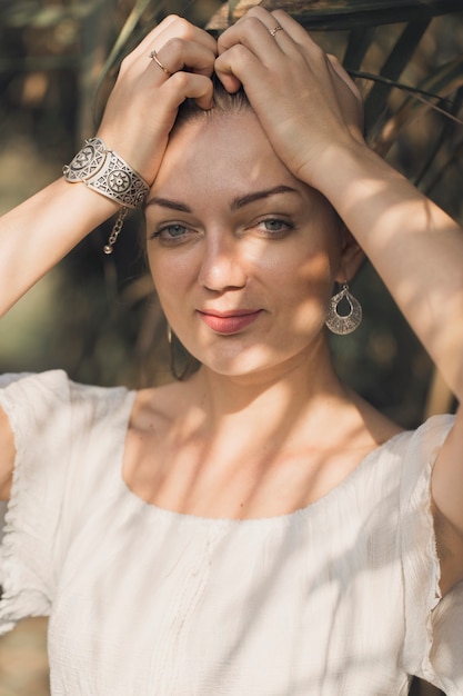 Portrait of a young beautiful girl in reeds in retro style in a light dress.