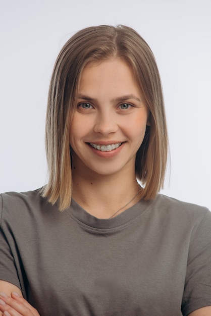 Portrait of a young beautiful girl with braces on a white background