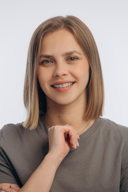 Portrait of a young beautiful girl with braces on a white background