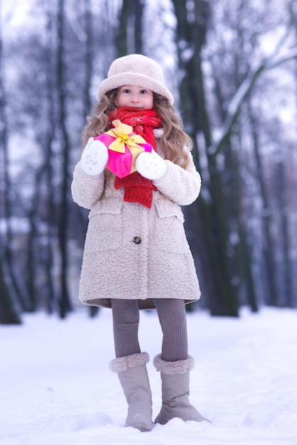 Portrait of young beautiful kid child girl in christmas decoration at winter snowy day near