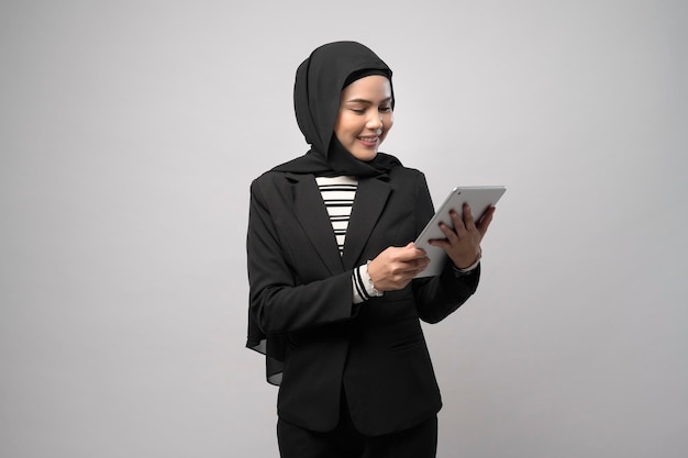 Portrait of young beautiful muslim businesswoman  is holding tablet over white background studio