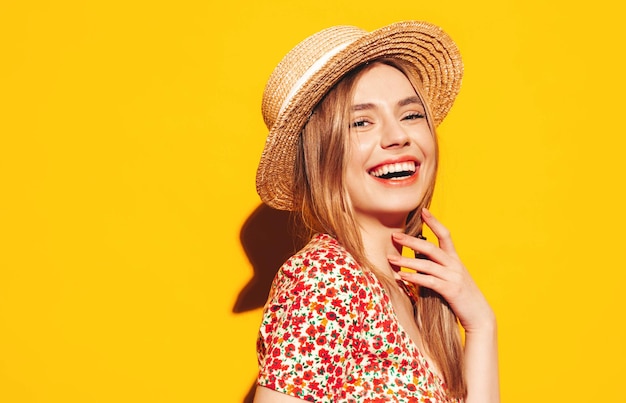 Portrait of young beautiful smiling blond female in trendy summer clothes carefree woman posing near yellow wall in studio Positive model having fun indoors Cheerful and happy In hat