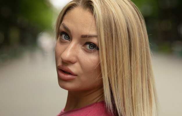 Portrait of a young beautiful smiling blonde woman outdoors